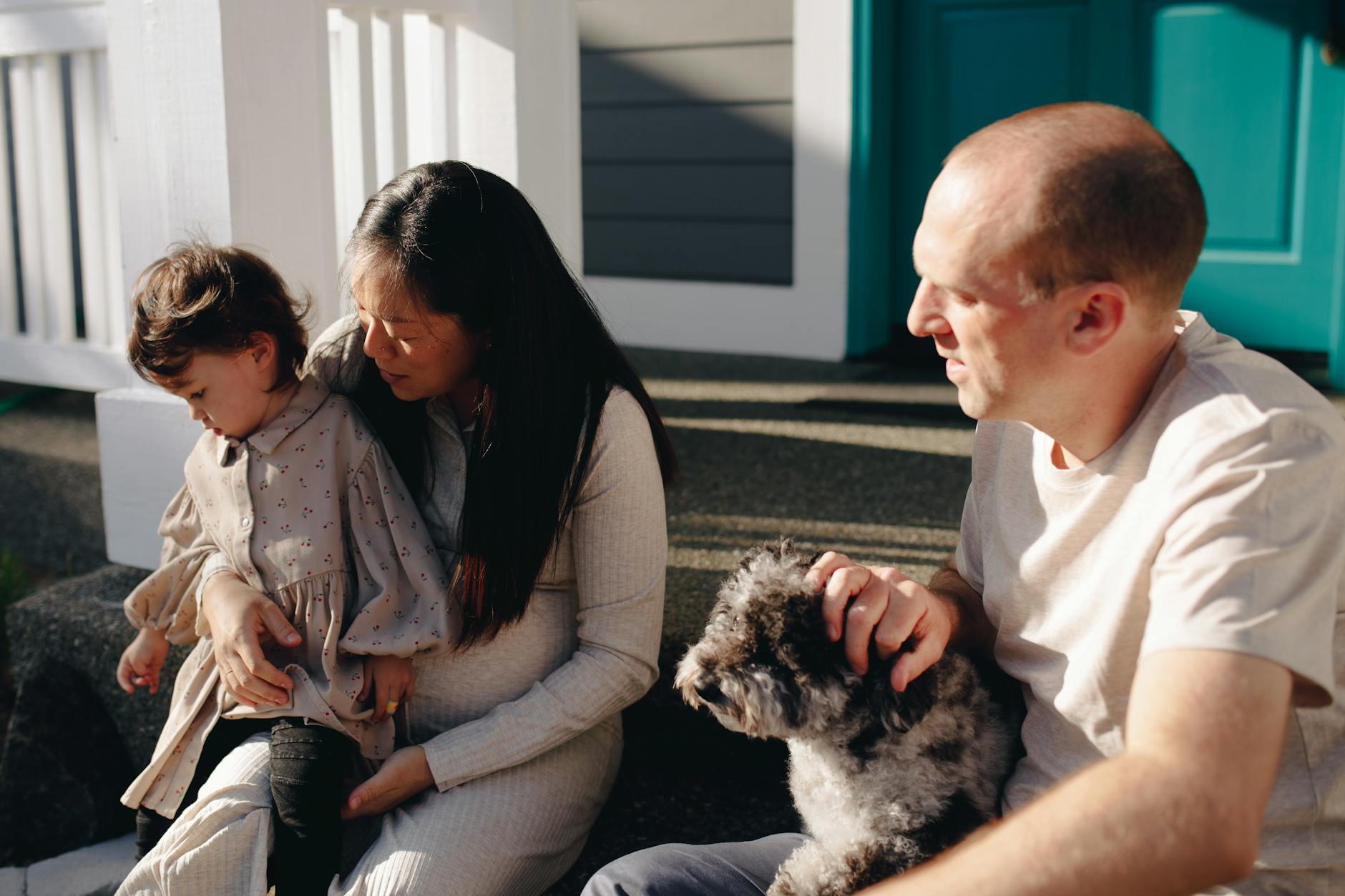 family sitting on the steps to a porch